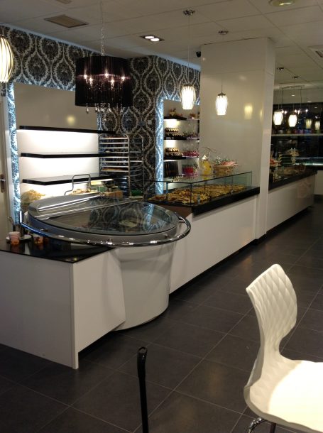 Estante de postres en una pastelería moderna con una decoración elegante.