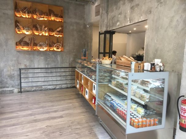 Interior de una panadería con exhibidor de productos y decoración minimalista.