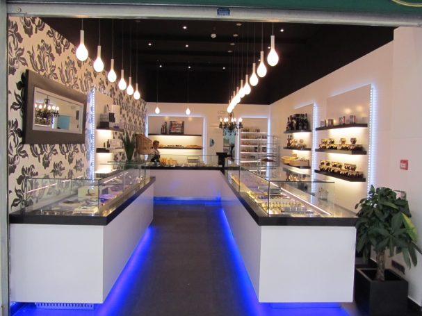 Interior de una joyería moderna con estanterías iluminadas y muebles modernos.