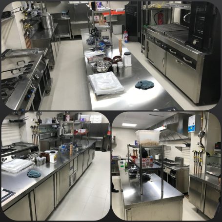 Cocina industrial equipada con estufas, mesas de trabajo y utensilios de cocina.